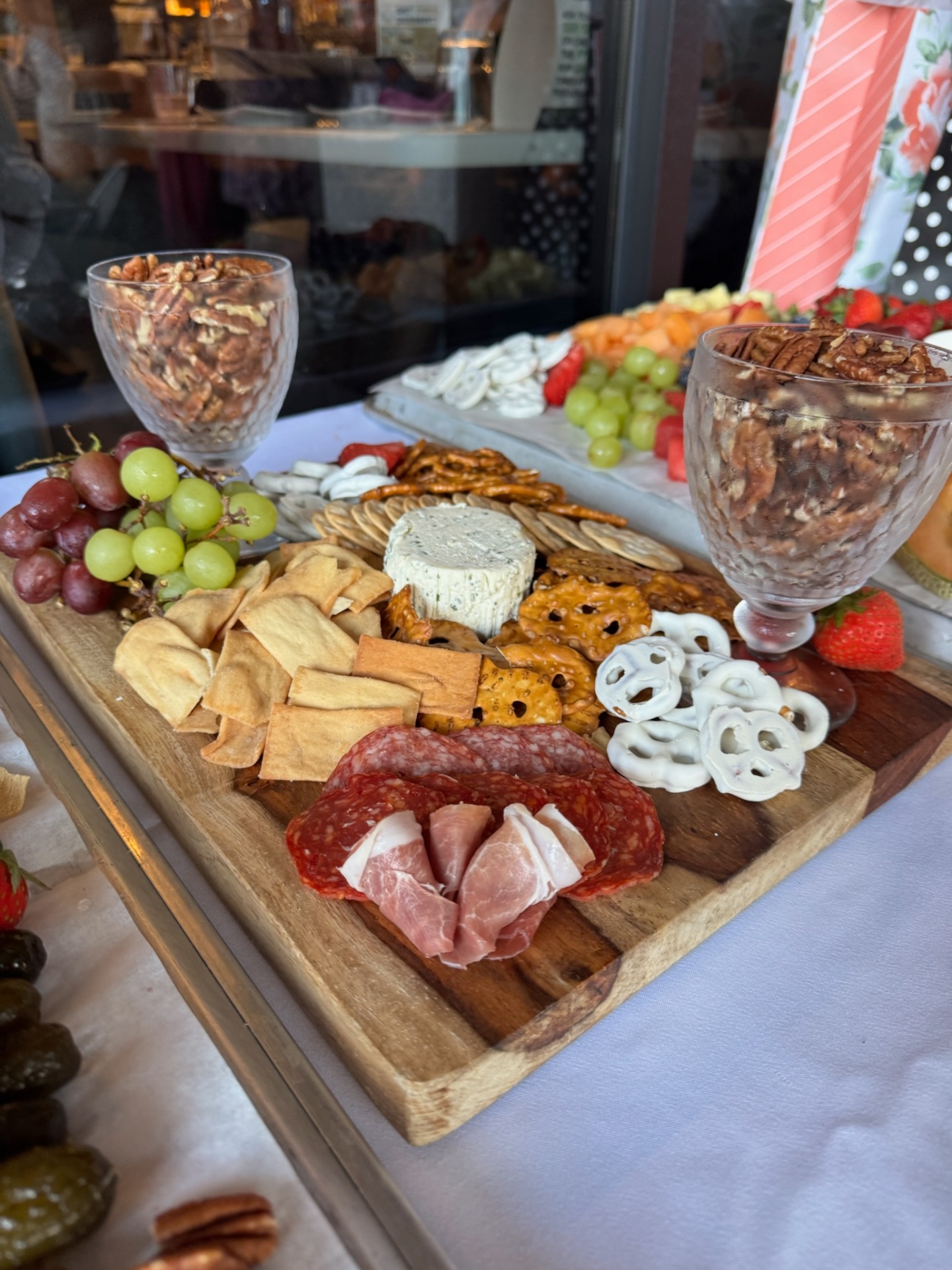 Charcuterie board with brie, pretzels and pecan goblets