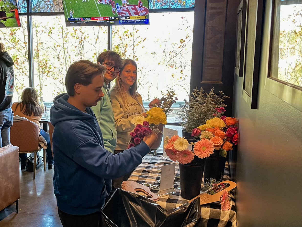 Private event setup with floral display and game on the TVs
