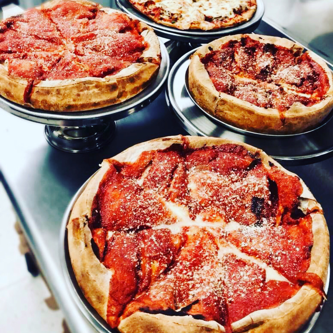 Stacked deep-dish pizzas fresh from the oven