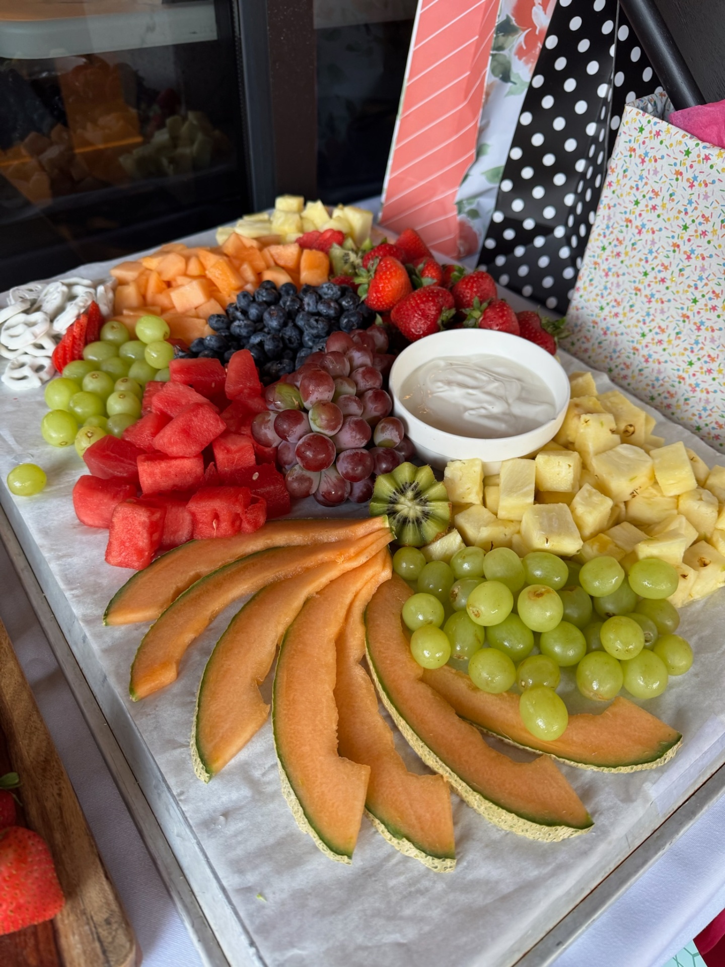 Flower-shaped fruit board with cantaloupe, grapes and dip