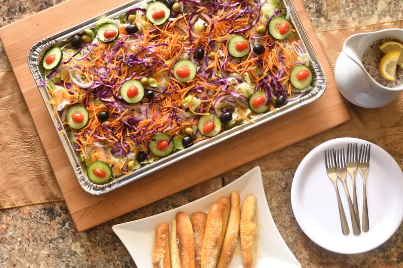 Garden salad tray with breadsticks and plates