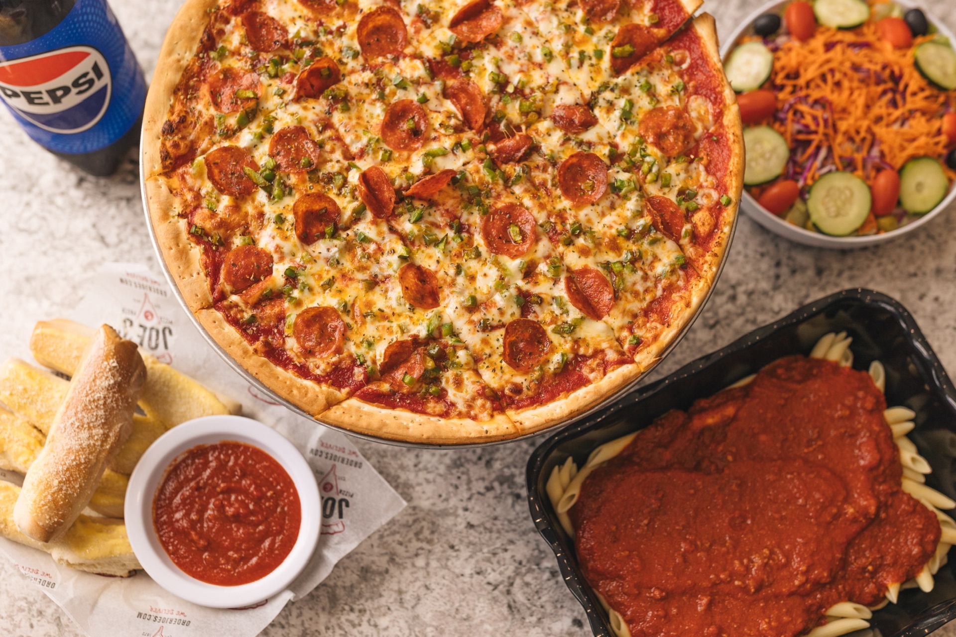 Pepperoni pizza, breadsticks, salad and pasta